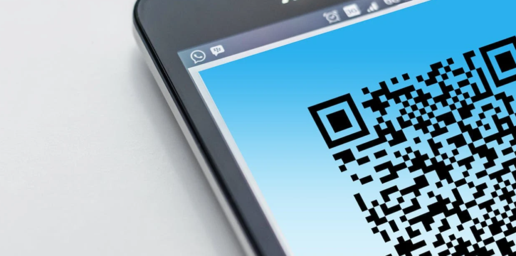 Close-up van een smartphonescherm met een grote QR-code, tegen een witte achtergrond.