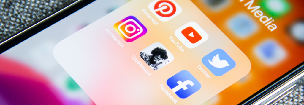 Close-up van een smartphonescherm met pictogrammen van sociale media-apps, waaronder Instagram, Pinterest, Clubhouse, Facebook, Twitter en YouTube die vatbaar zijn voor vormen van phishing.